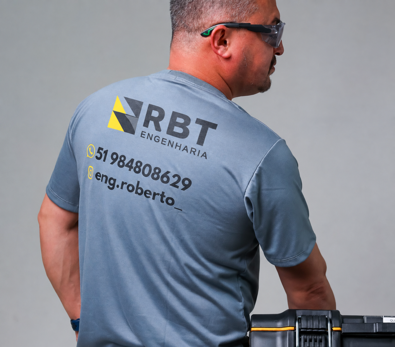 Uniforme da RBT Engenharia com logo, telefone e Instagram da empresa