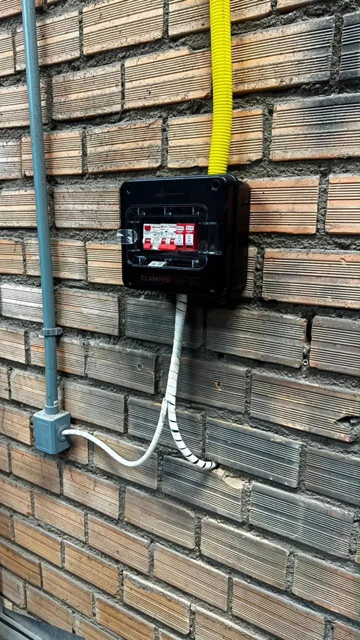 Caixa de proteção do circuito do wallbox com eletroduto aparente em parede de tijolos