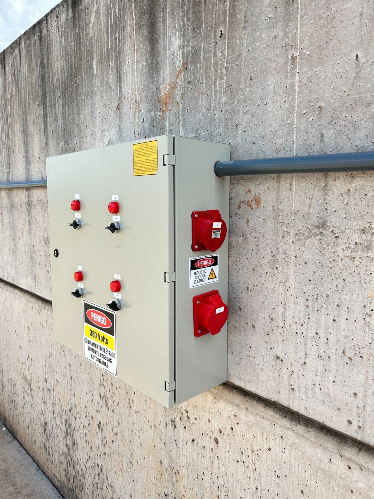 Quadro de comando industrial instalado em parede com botoeiras e tomadas industriais